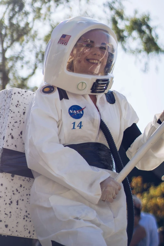 this woman is dressed in space costumes and carrying a white piece of luggage