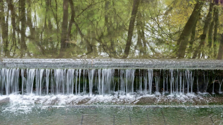 a large flowing waterfall on the side of a road