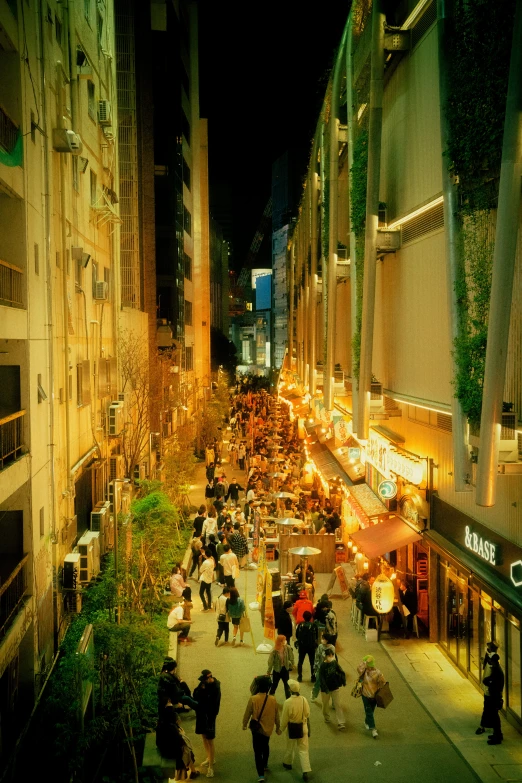 people walking down the sidewalk in a city at night