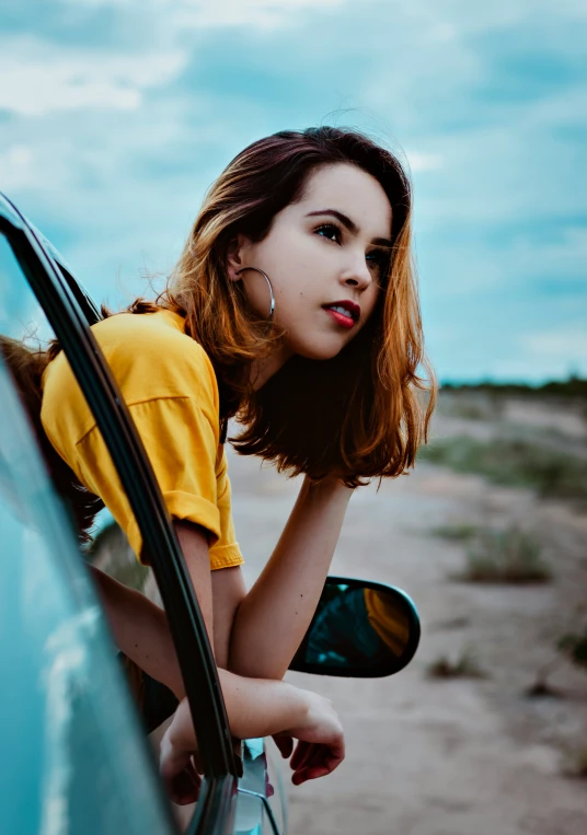 a woman leaning out the window of a car