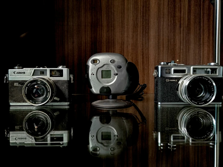 four cameras are sitting next to each other on a table