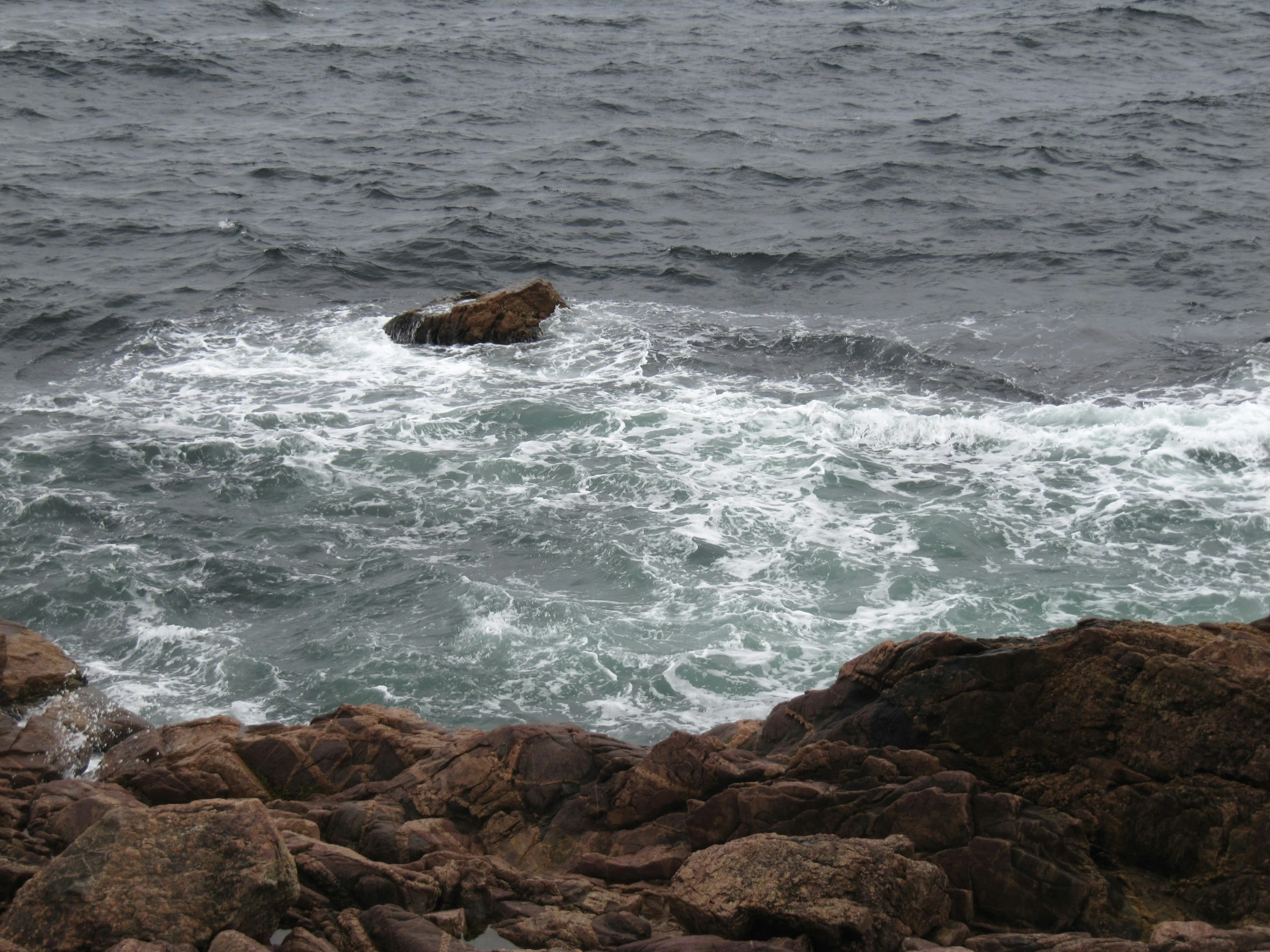 a rocky shore with waves hitting the rocks