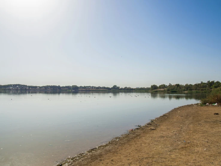 clear lake water and some sand with houses on the side