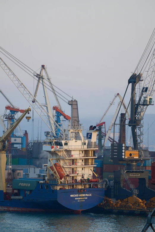 some cargo ships are on a small body of water