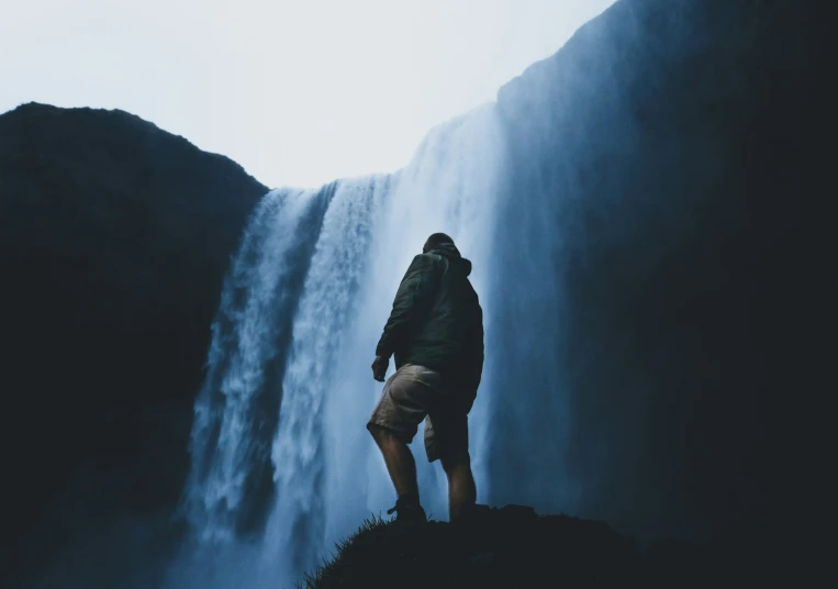 a man is standing in front of the falls