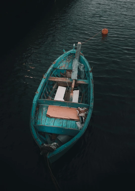 a blue wooden boat floating on top of the water