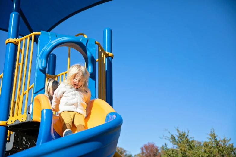 an older lady is standing at the top of a slide