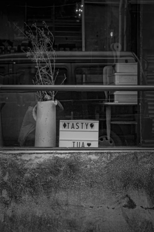 a plant in a vase with a sign posted in front