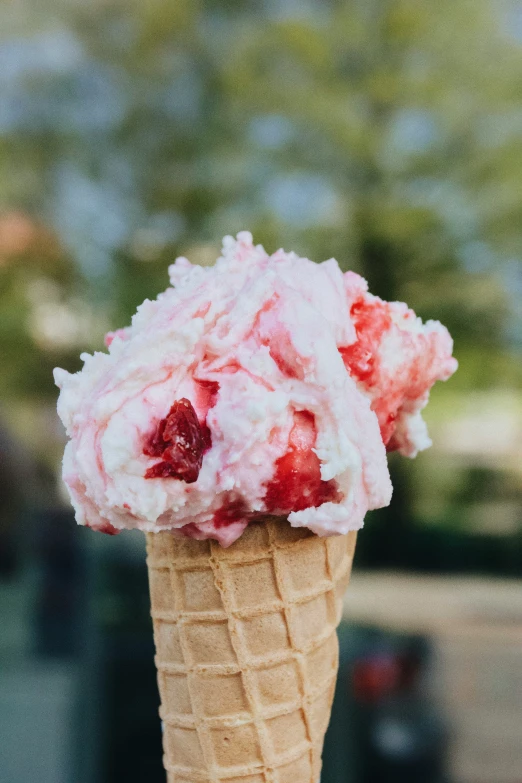 strawberry salad in an ice cream cone with some sort of powdered sugar topping