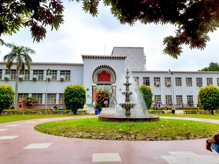 a circular stone fountain in front of a building