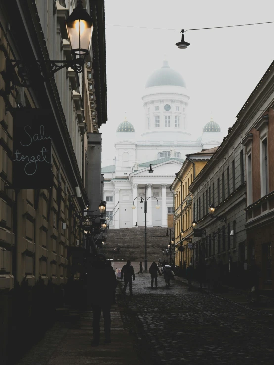 a man walks down a dark alley past a cathedral