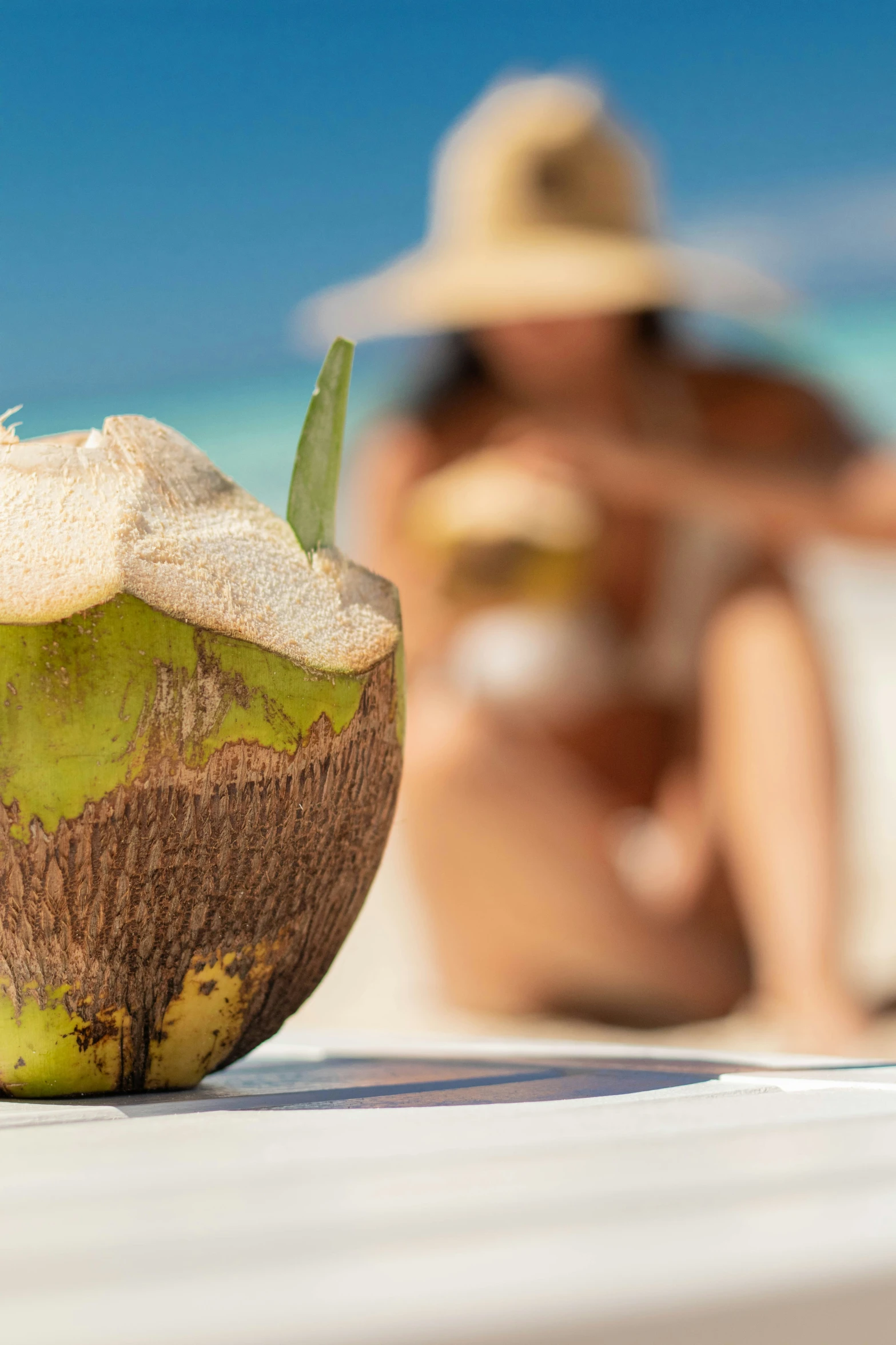 a coconut is sitting on the beach with the man taking a po