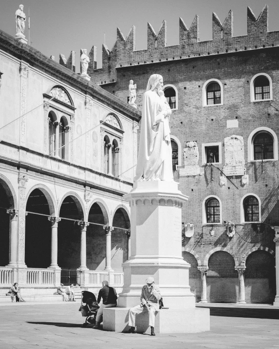 statue and benches in front of a large building