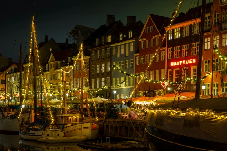 a harbor with many boats filled with lights and christmas decorations