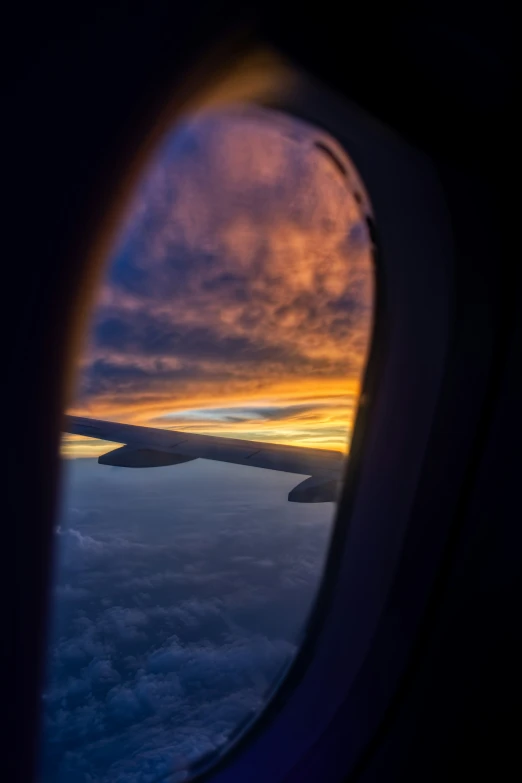 the sun is setting as seen from the window of an airplane