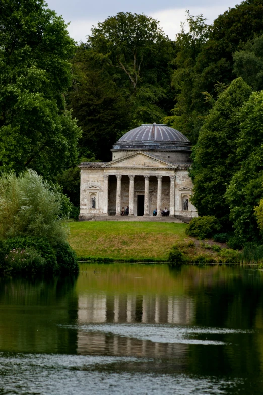 an old mansion with two pillars across the water