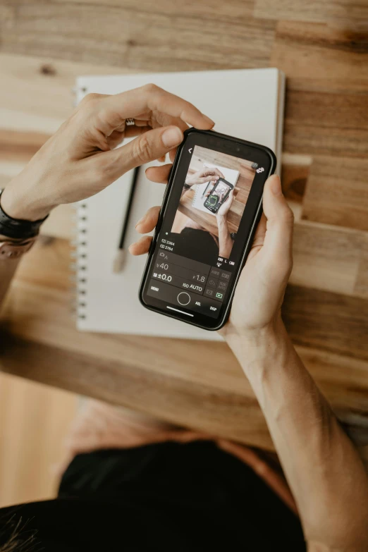 a person holding a phone showing the screen with pictures on it