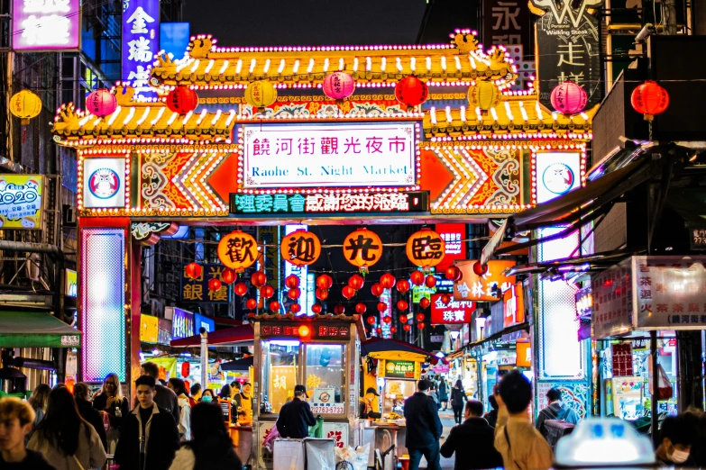 an outdoor chinese market with people walking through the alley