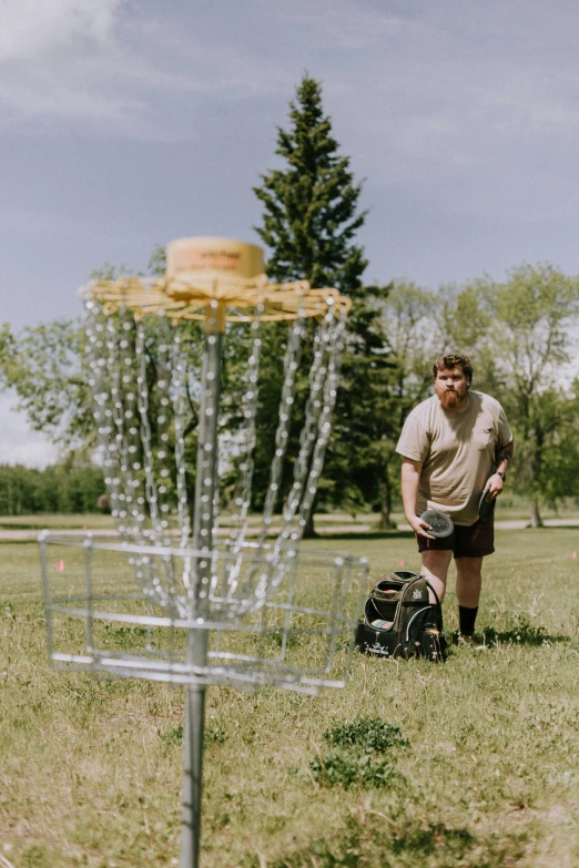 a man standing in the grass in front of a bag