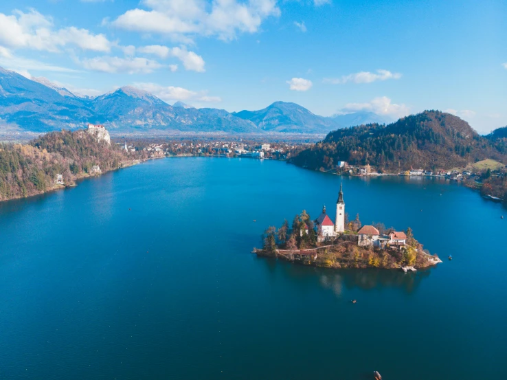 an island in the middle of a lake near mountains