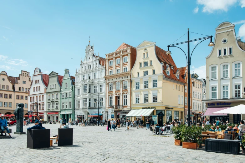 people in an open air square with umbrellas