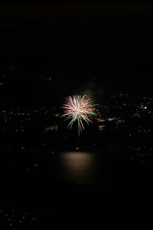 fireworks in the sky above water and city