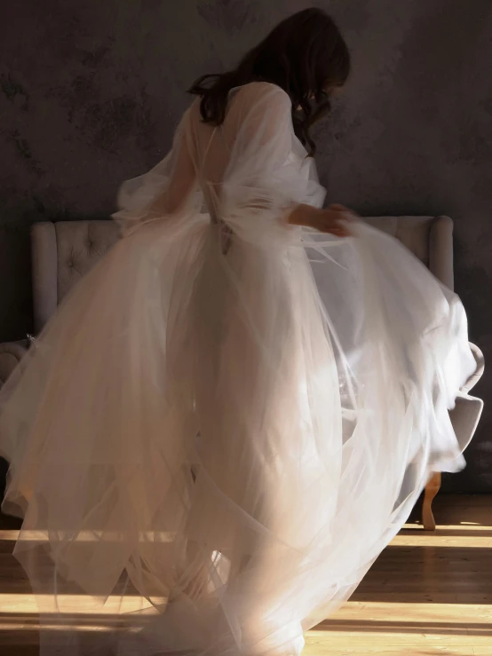 a woman is kneeling down while in a white dress