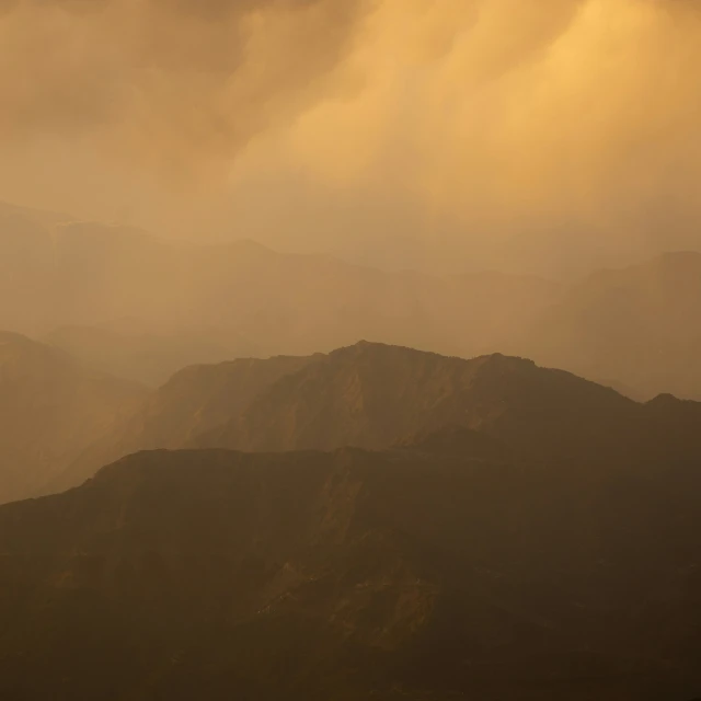 the top of a large mountain with an airplane above it