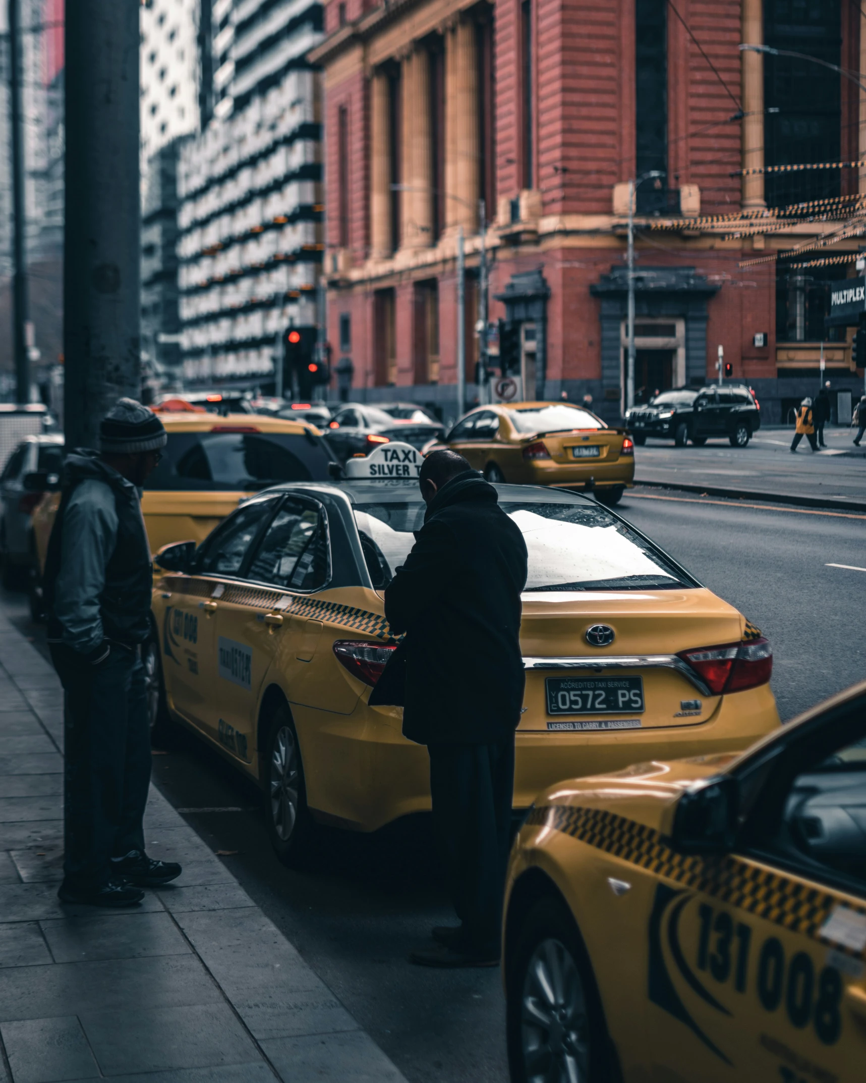 taxis and cars waiting on a city street