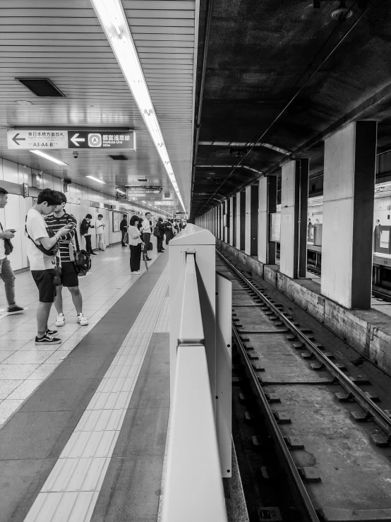 a black and white po of people at an indoor metro station