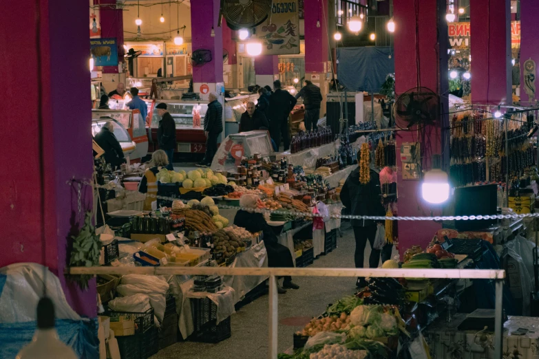 an indoor market with people shopping in the market stalls