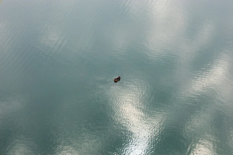 two people paddling in small boats on a lake