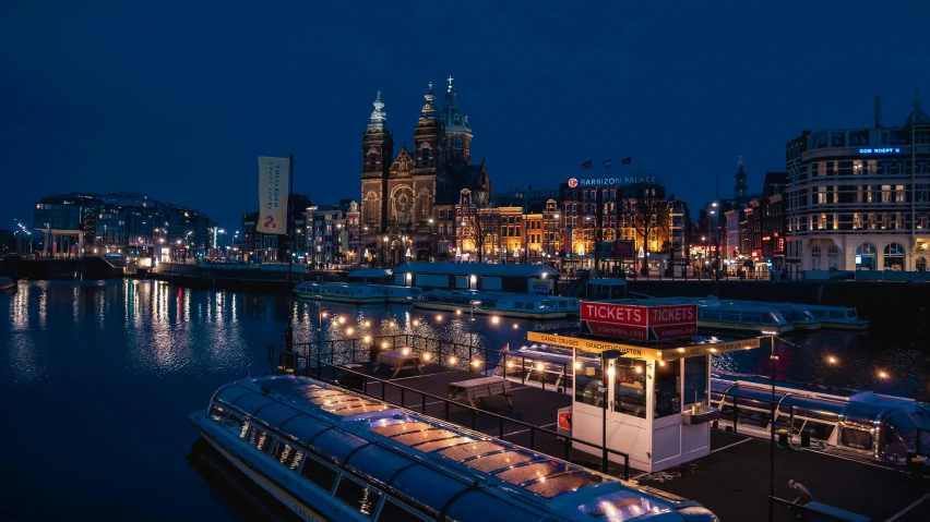 an empty bus near a body of water with lights at night