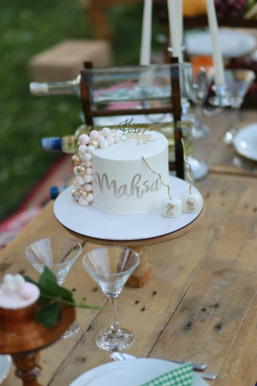 a table with a white cake and glasses