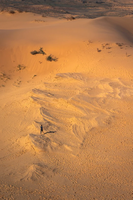 man walking in the sand with no cars