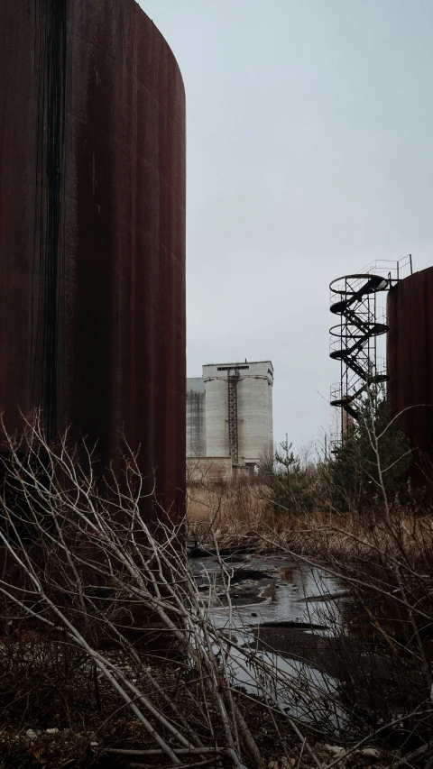 an old factory with a rusting metal fence in front