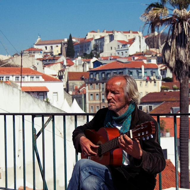 man playing a guitar in front of cityscape