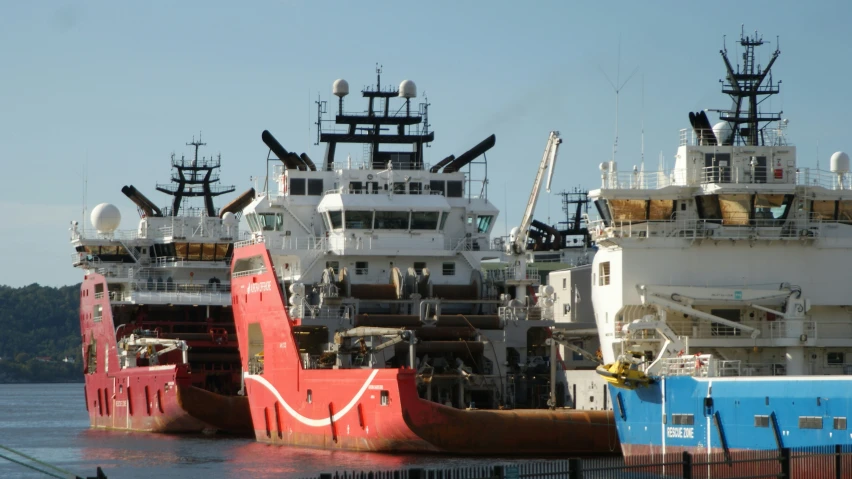 three large ships sitting side by side in the water