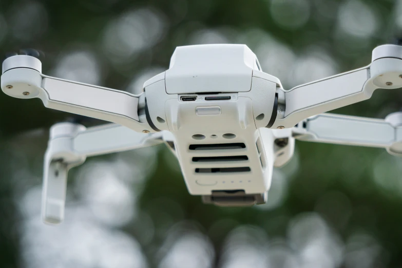 a large white device with two propellers and a tree in the background