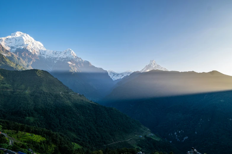 the snow covered mountains with green valleys in between