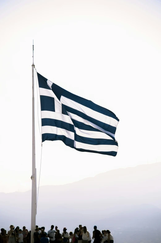 people standing in front of the flag flying in the sky