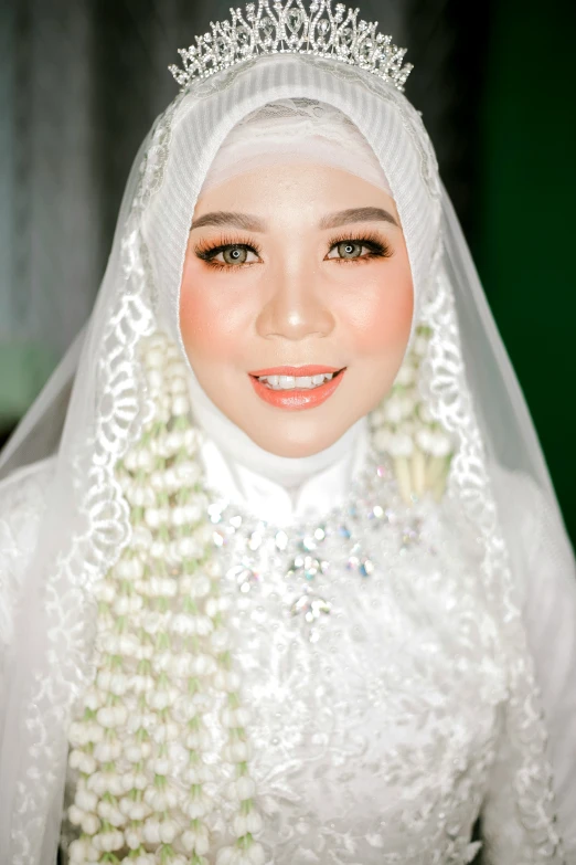 a woman dressed in a white dress and headpiece is posing for the camera