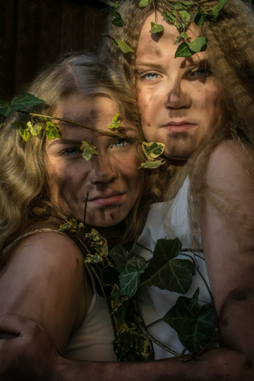 two women are posing for a po while covered in plants