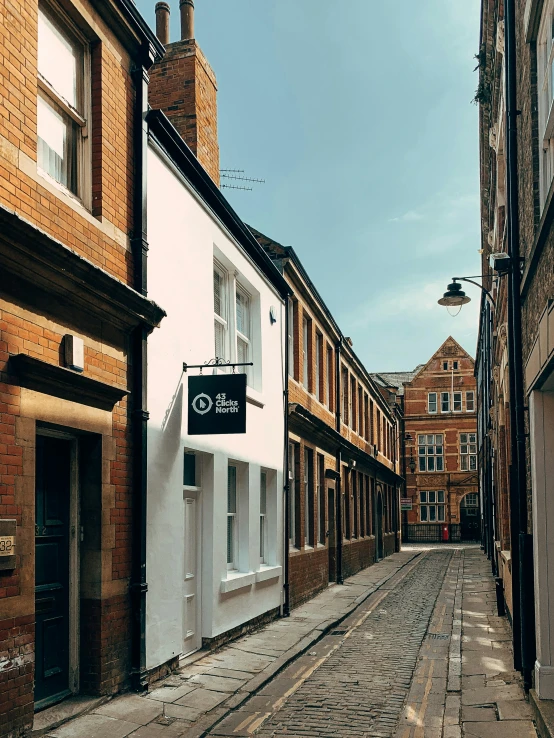 a cobblestone street with a sign for a shop