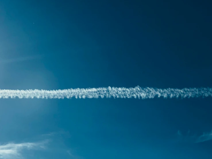 an air plane contrail in the sky with it's contrails