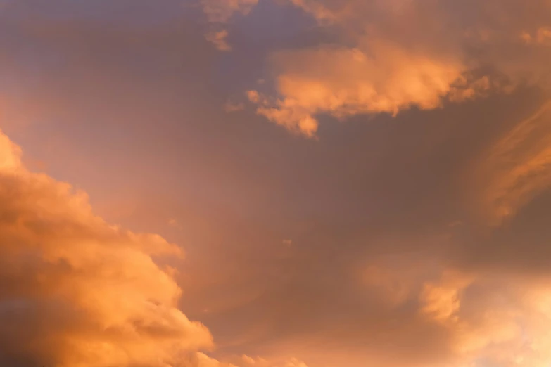 airplane in cloudy skies with golden clouds on sunset