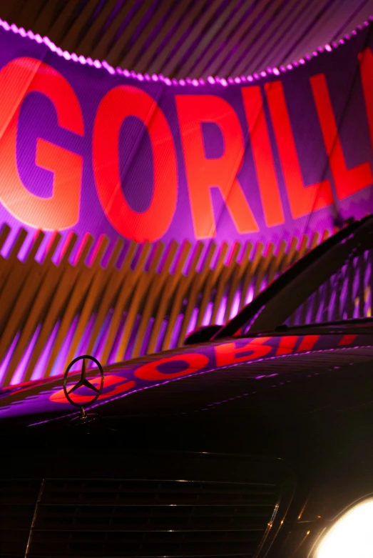 a purple gorilla sign hangs over the front of a car