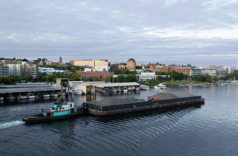 a tug boat moving along water next to a harbor