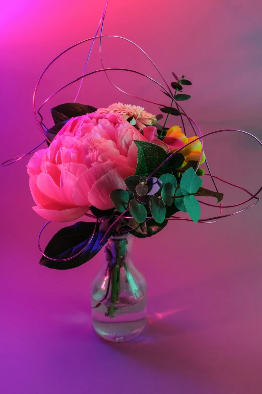 a glass vase filled with colorful flowers sitting on top of a purple table