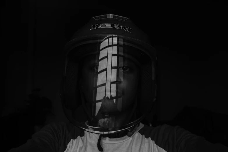 black and white pograph of a man wearing a helmet with the text sticker on it